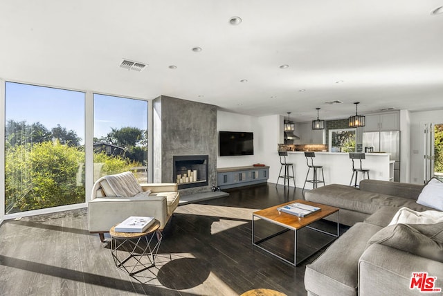 living room with a large fireplace and dark hardwood / wood-style flooring