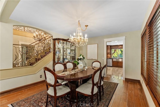 dining area with hardwood / wood-style floors and an inviting chandelier