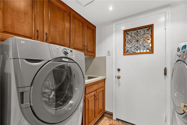 laundry area featuring cabinets and washing machine and clothes dryer