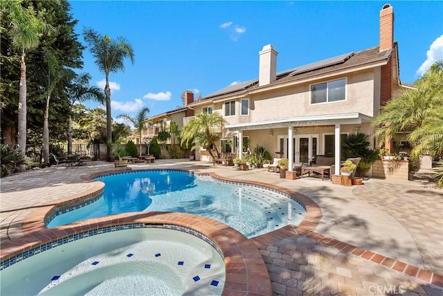 view of swimming pool with a patio area, an in ground hot tub, and french doors