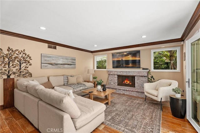 living room with ornamental molding and a brick fireplace