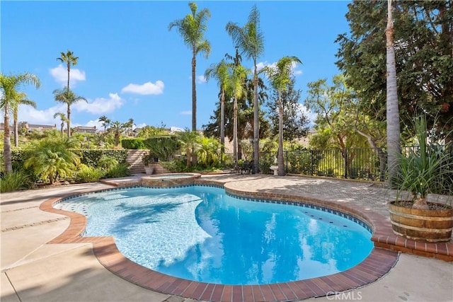 view of pool featuring a patio area and an in ground hot tub