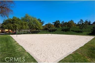 view of community with volleyball court and a lawn