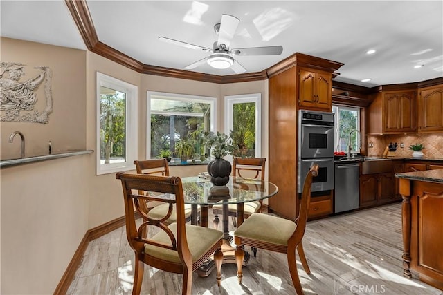 kitchen featuring decorative backsplash, appliances with stainless steel finishes, ceiling fan, sink, and dark stone countertops