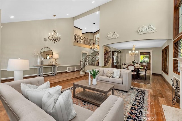 living room featuring a high end fireplace, wood-type flooring, and high vaulted ceiling