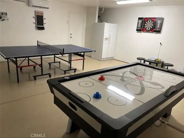 recreation room with a wall mounted air conditioner and concrete flooring