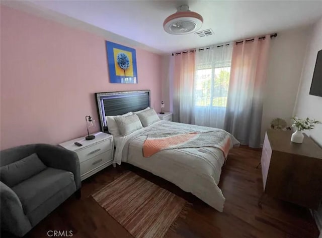 bedroom with dark hardwood / wood-style flooring