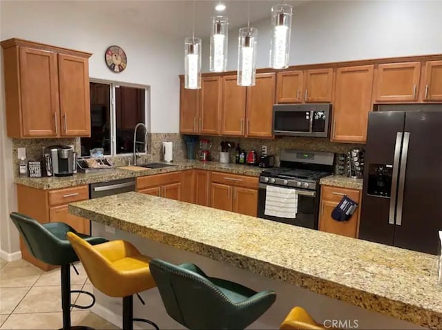 kitchen featuring a kitchen breakfast bar, backsplash, stainless steel appliances, and sink