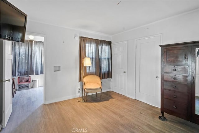 sitting room featuring wood-type flooring and ornamental molding