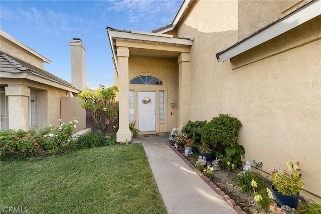 entrance to property with a lawn