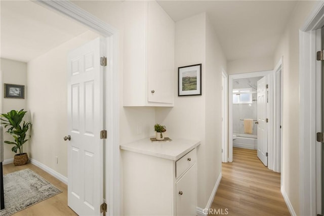 corridor with light hardwood / wood-style flooring