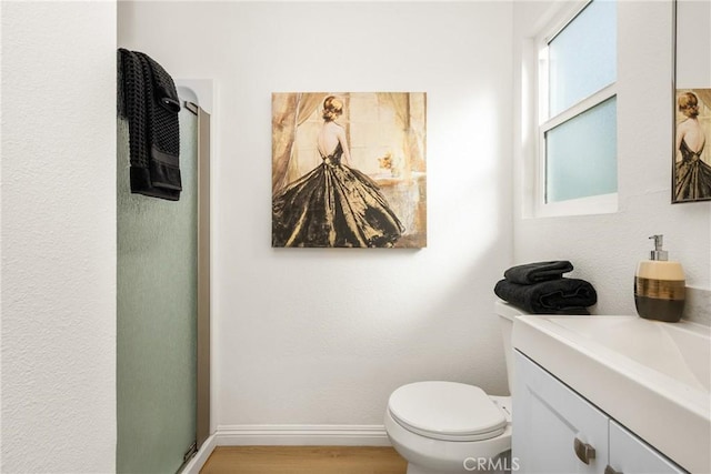 bathroom with vanity, hardwood / wood-style flooring, toilet, and walk in shower