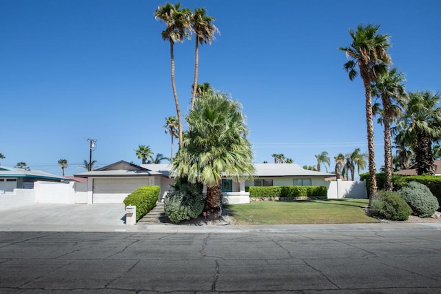 single story home featuring a front lawn and a garage