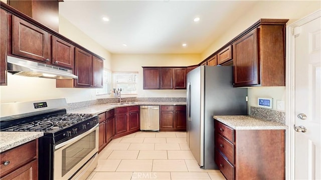 kitchen featuring light tile patterned floors, appliances with stainless steel finishes, sink, and light stone counters