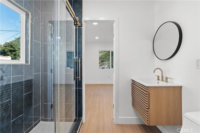 bathroom featuring plenty of natural light, an enclosed shower, wood-type flooring, and vanity