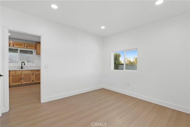 empty room with light hardwood / wood-style floors and sink