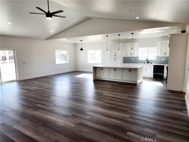 unfurnished living room featuring ceiling fan, dark hardwood / wood-style flooring, lofted ceiling, and sink