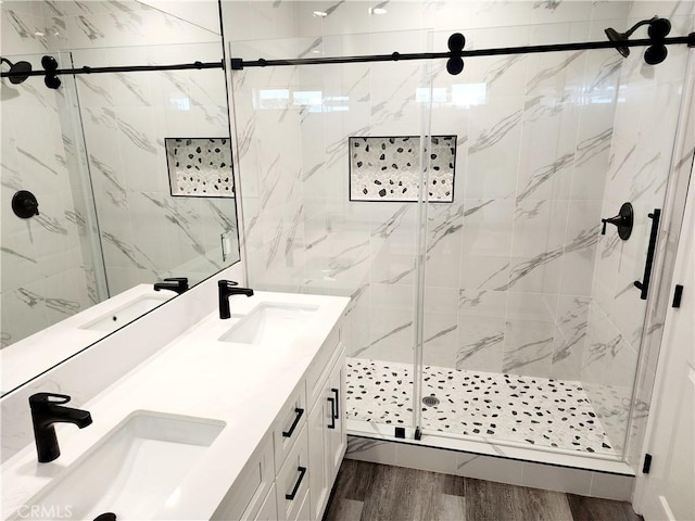 bathroom with hardwood / wood-style floors, walk in shower, and vanity