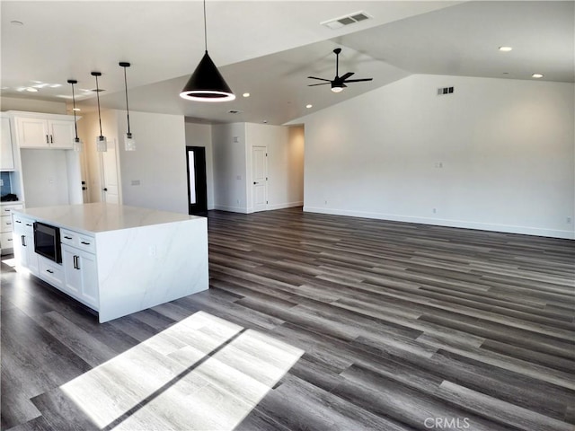 kitchen featuring white cabinetry, lofted ceiling, and a kitchen island