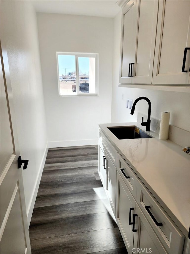 interior space with washer hookup, cabinets, dark hardwood / wood-style flooring, and sink