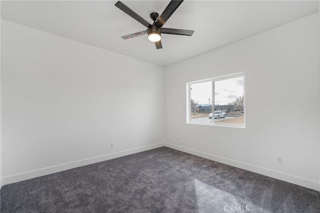 unfurnished room featuring ceiling fan, dark carpet, and baseboards