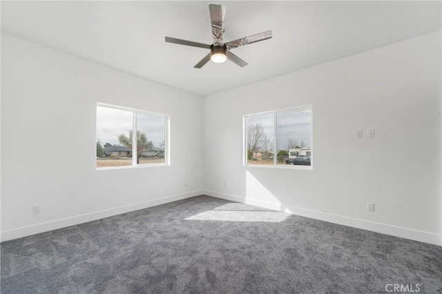 carpeted empty room with a ceiling fan, a wealth of natural light, and baseboards