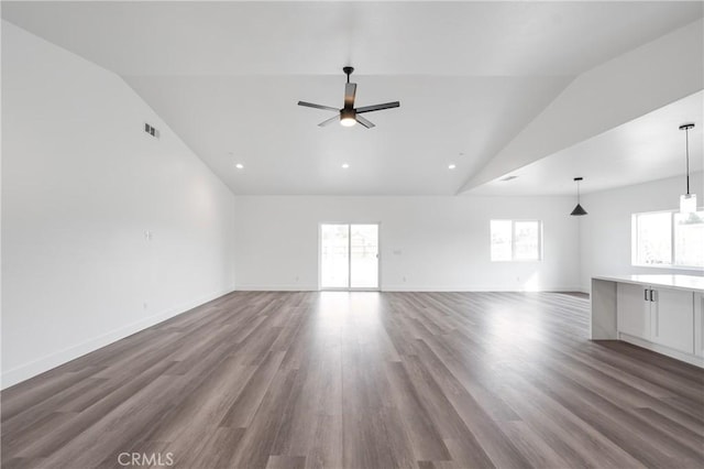 unfurnished living room featuring visible vents, dark wood-type flooring, vaulted ceiling, ceiling fan, and baseboards