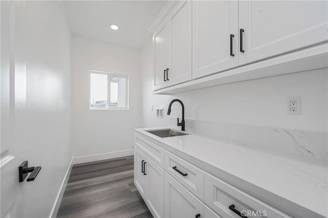 bar with dark wood-style floors, recessed lighting, a sink, and baseboards