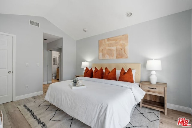 bedroom with light hardwood / wood-style floors and vaulted ceiling