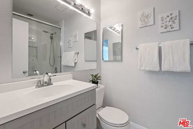 bathroom featuring toilet, vanity, and walk in shower