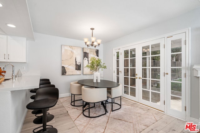 dining space featuring a chandelier, a wealth of natural light, sink, and light hardwood / wood-style floors