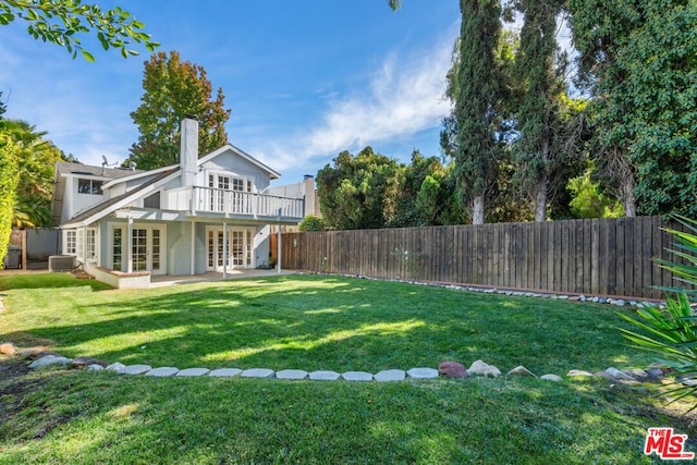 view of yard with french doors, a patio, and central AC unit