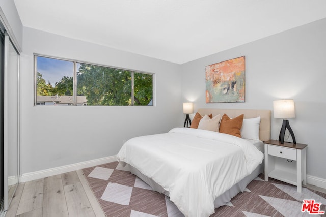 bedroom with light hardwood / wood-style flooring and a closet