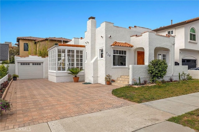 mediterranean / spanish-style house with a sunroom and a garage