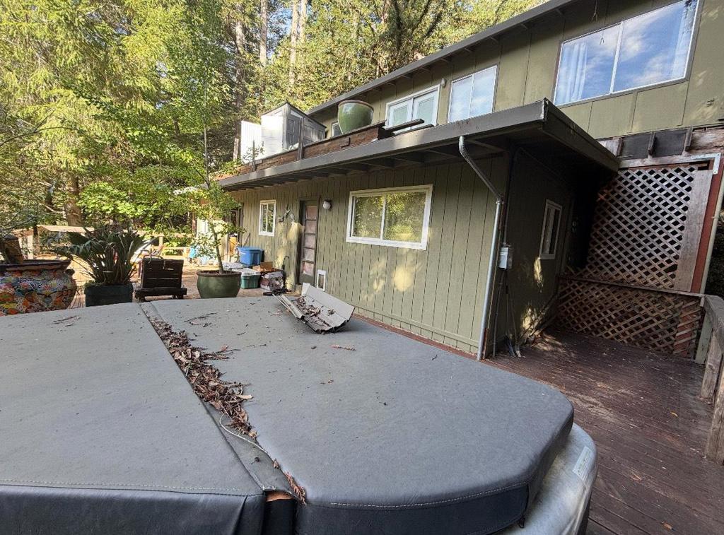 exterior space featuring a hot tub, a patio area, and a wooden deck