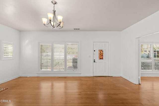 foyer entrance featuring a chandelier and hardwood / wood-style flooring