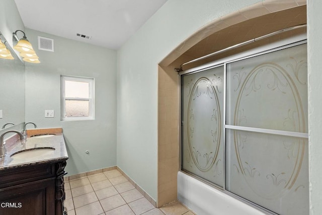 bathroom with tile patterned flooring, vanity, and bath / shower combo with glass door