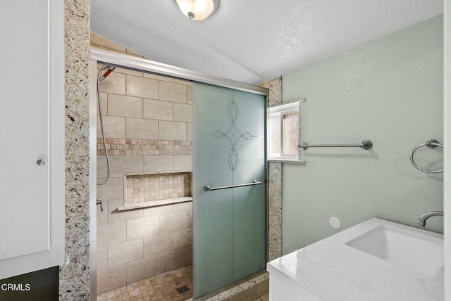 bathroom featuring a textured ceiling, lofted ceiling, sink, and an enclosed shower