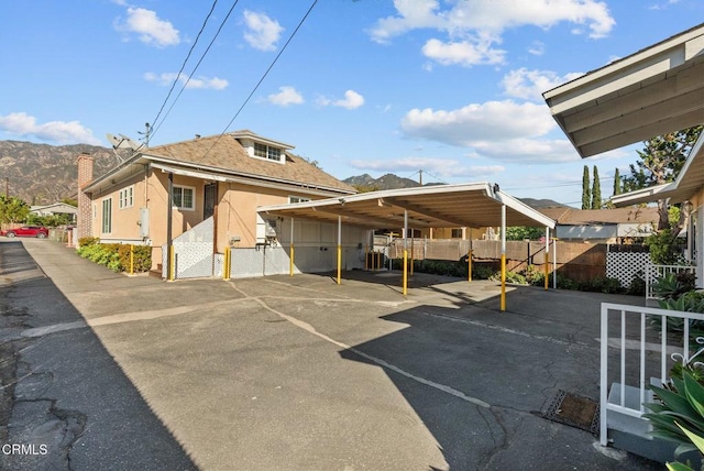 view of parking with a mountain view and a carport