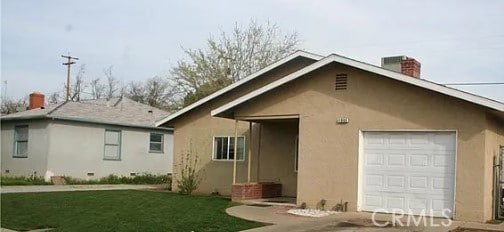 back of house with a yard and a garage