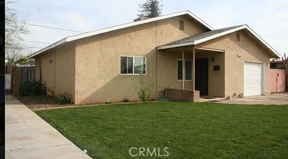 rear view of property featuring a lawn and a garage