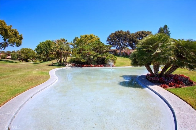 view of pool with a lawn