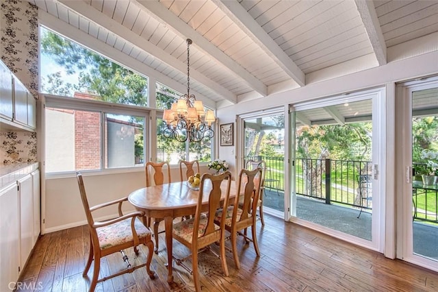 dining space featuring lofted ceiling with beams, a chandelier, and hardwood / wood-style flooring