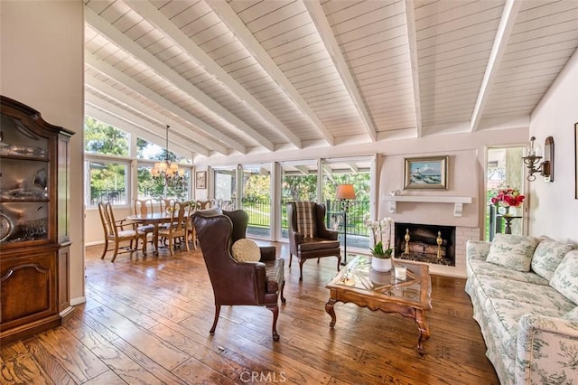 living room with a chandelier, a brick fireplace, high vaulted ceiling, wood-type flooring, and beamed ceiling