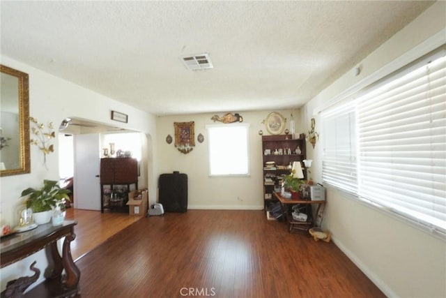 miscellaneous room featuring dark wood-type flooring and a textured ceiling