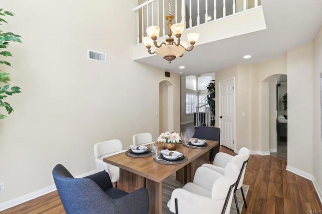 dining room with dark hardwood / wood-style flooring and a notable chandelier