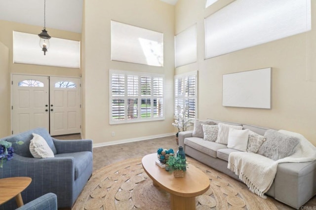 living room featuring a towering ceiling and light tile patterned floors