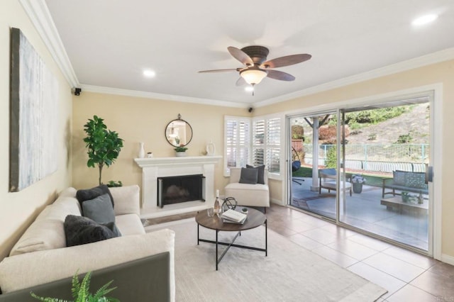 tiled living room with ceiling fan and crown molding