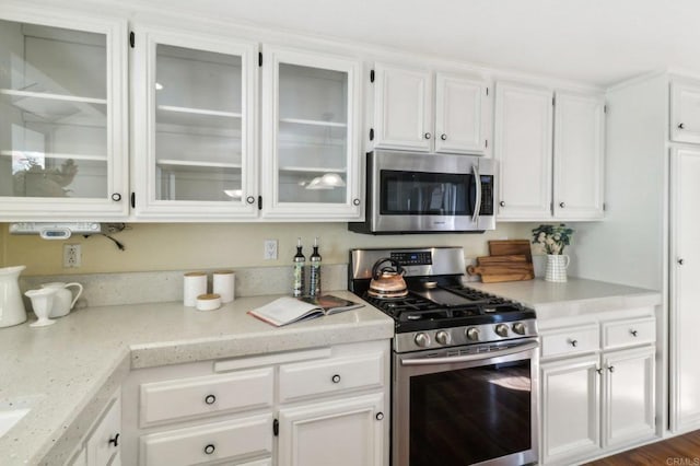 kitchen featuring white cabinetry, stainless steel appliances, and dark wood-type flooring