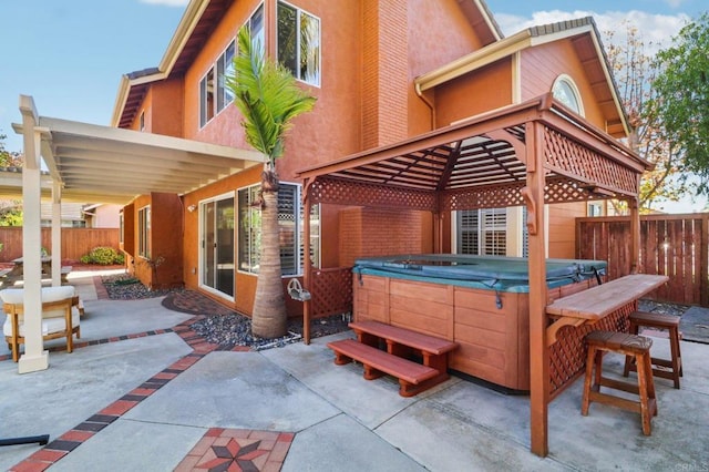 back of house featuring a patio and a hot tub